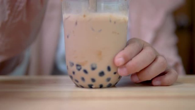 桌上用塑料吸管搅拌台湾泡泡奶茶。