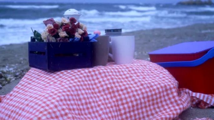 海滩上毯子上的野餐篮