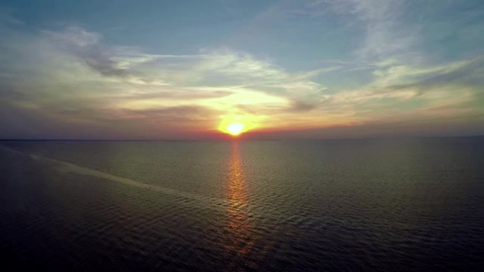 无人机在海岸的渔船上朝着夕阳飞行