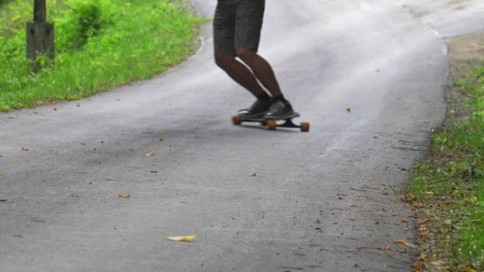 男子在沥青路面上骑长板滑板慢动作