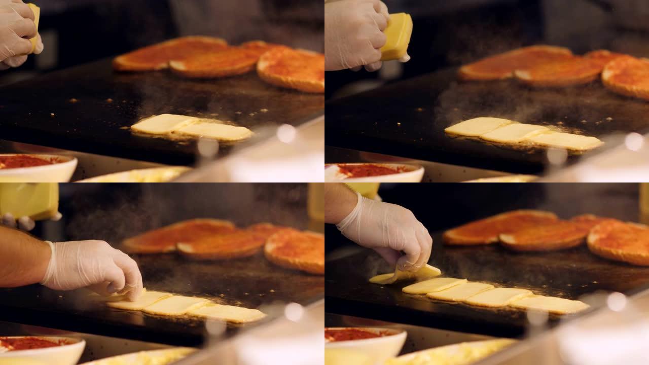 库克将奶酪切片分解在热金属板上。在厨房准备三明治作为早餐。