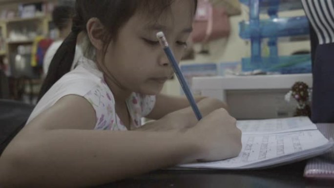 亚洲女婴小学年龄做英语作业。