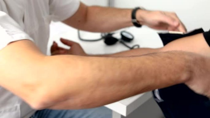 医生测量男性患者的血压