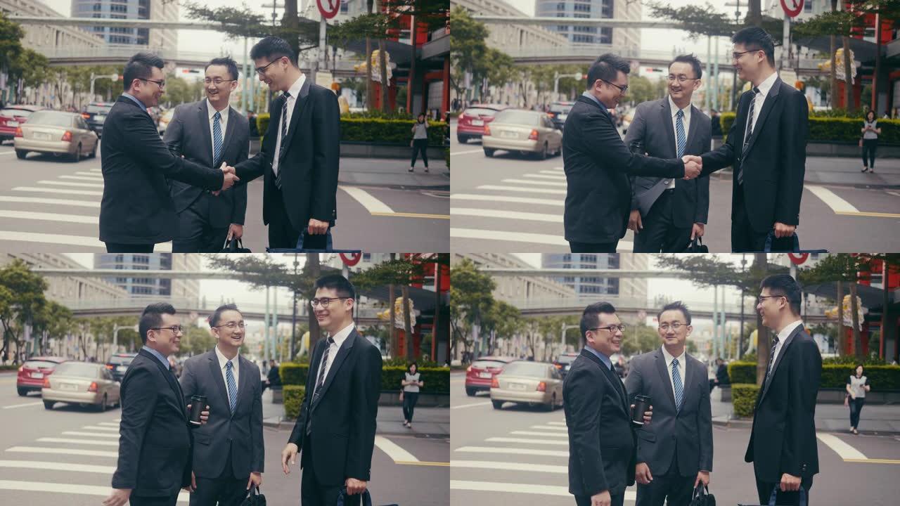 三名亚洲商人在街角见面握手