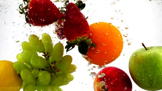 苹果，猕猴桃，橙子，梨，柠檬，葡萄和草莓落入水中，并带有气泡。慢动作录像