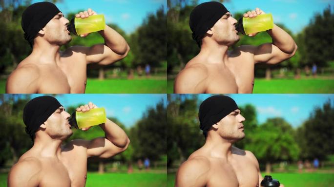 清晨，在公园里，他的黄色运动瓶中喝着完美的躯干运动员。英俊的运动员晨跑后休息。口渴的人在户外锻炼后喝