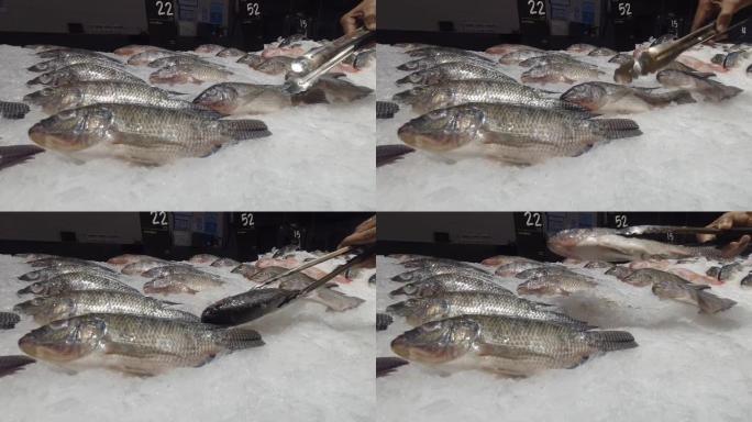 消费者在海鲜市场采摘尼罗罗非鱼
