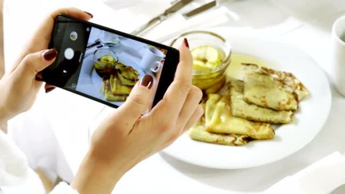 苹果果酱煎饼。用智能手机为早餐拍照。4K