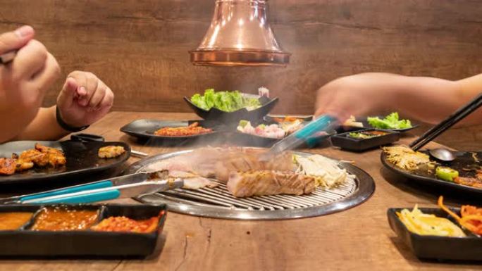 时间流逝: 亚洲人在韩国餐馆烧烤烧烤。食品概念