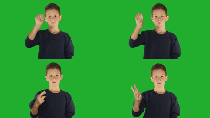 聋哑男孩签名我知道手语，听力障碍的交流。绿屏