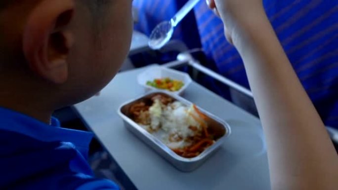 小男孩在飞机上吃飞机餐