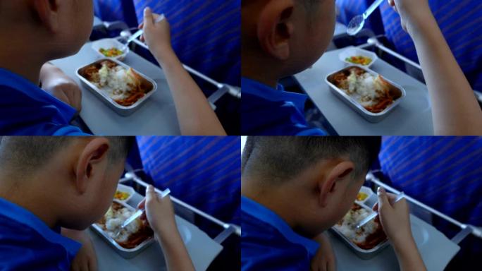小男孩在飞机上吃飞机餐