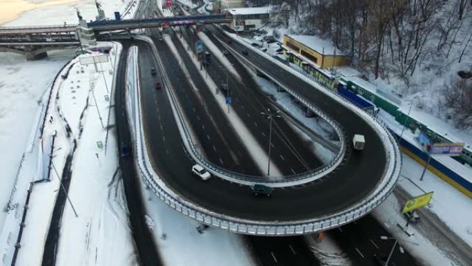 路口的汽车交通。无人机观看在冬季高速公路上行驶的汽车