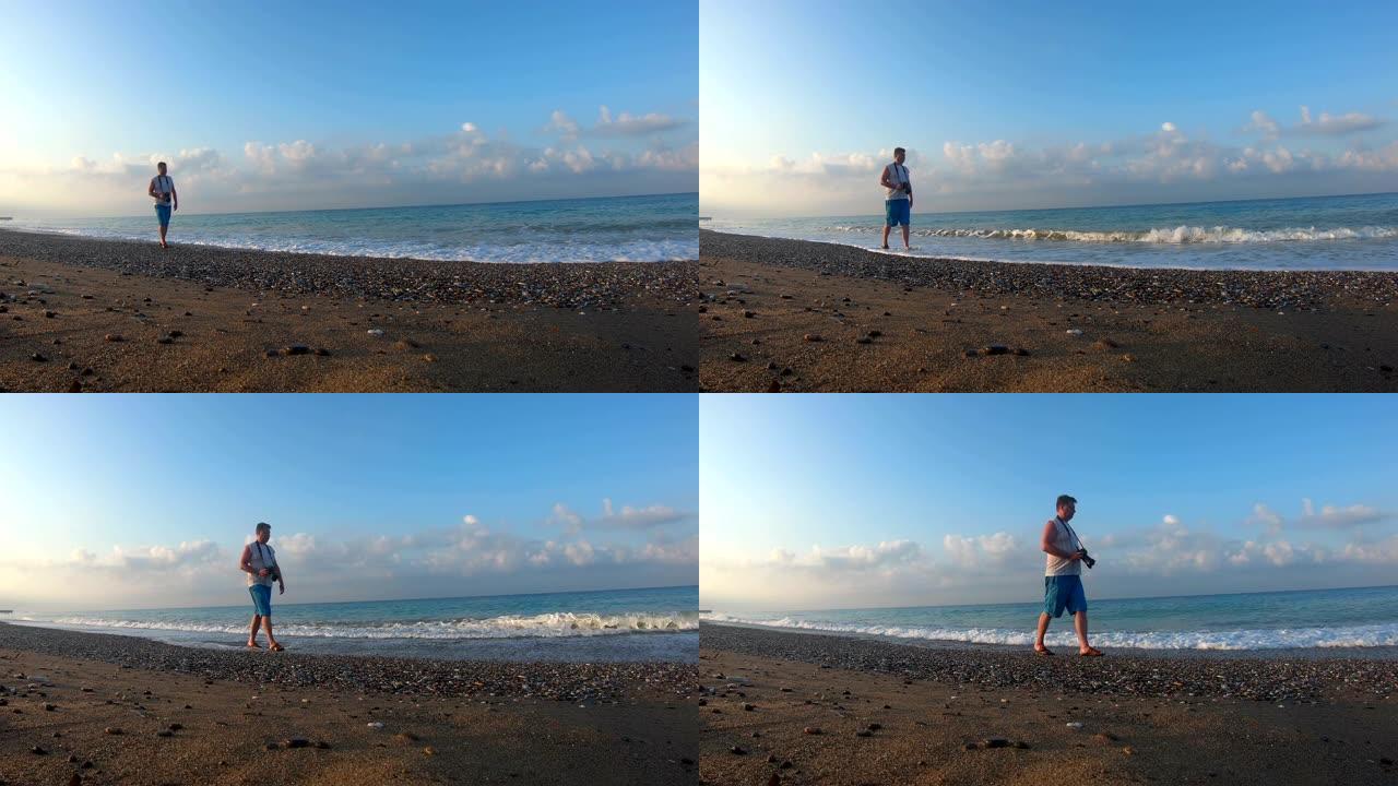 摄影师在黎明时走在海滩上。