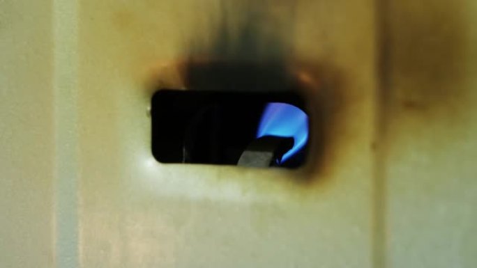 间歇泉，热水器。火炬的火焰燃烧，气体铜用于水加热。锅炉炉内天然气点火燃烧的特写