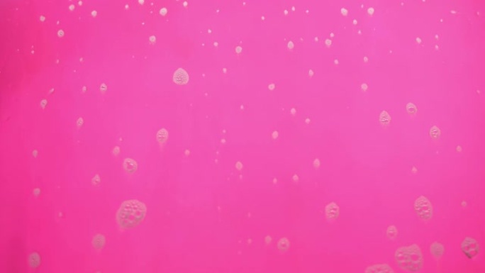 泡沫泡沫从肥皂流动在粉红色的背景。