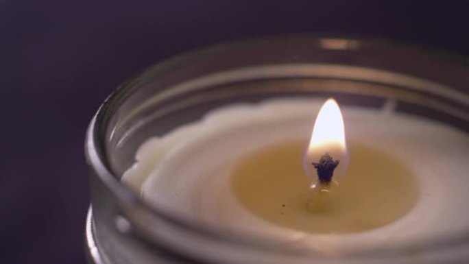 被熔化的蜡包围的蜡烛火焰的极端特写