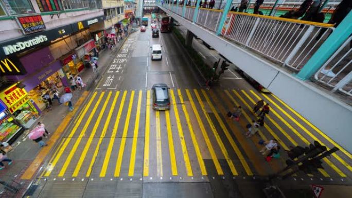 雨时在斑马线或人行横道上行走的人群的俯视图的时间流逝。繁忙城市的交通道路。香港市区。