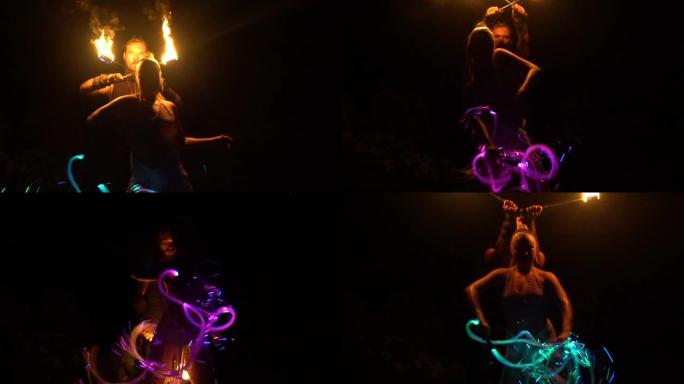 一个男人手里拿着火和一个女孩拿着霓虹灯鞭子的夜间视频拍摄。