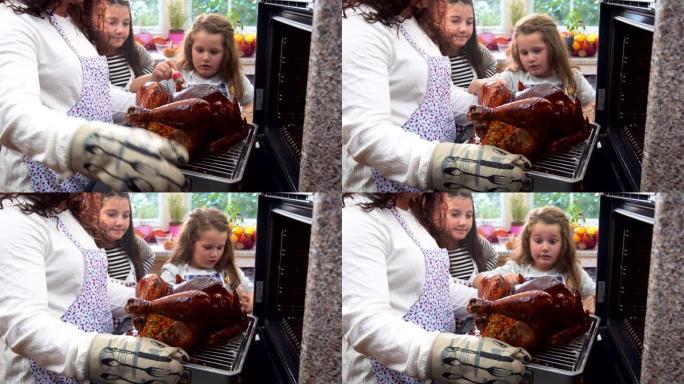 为感恩节晚餐准备火鸡，女儿帮助母亲将火鸡涂在一起