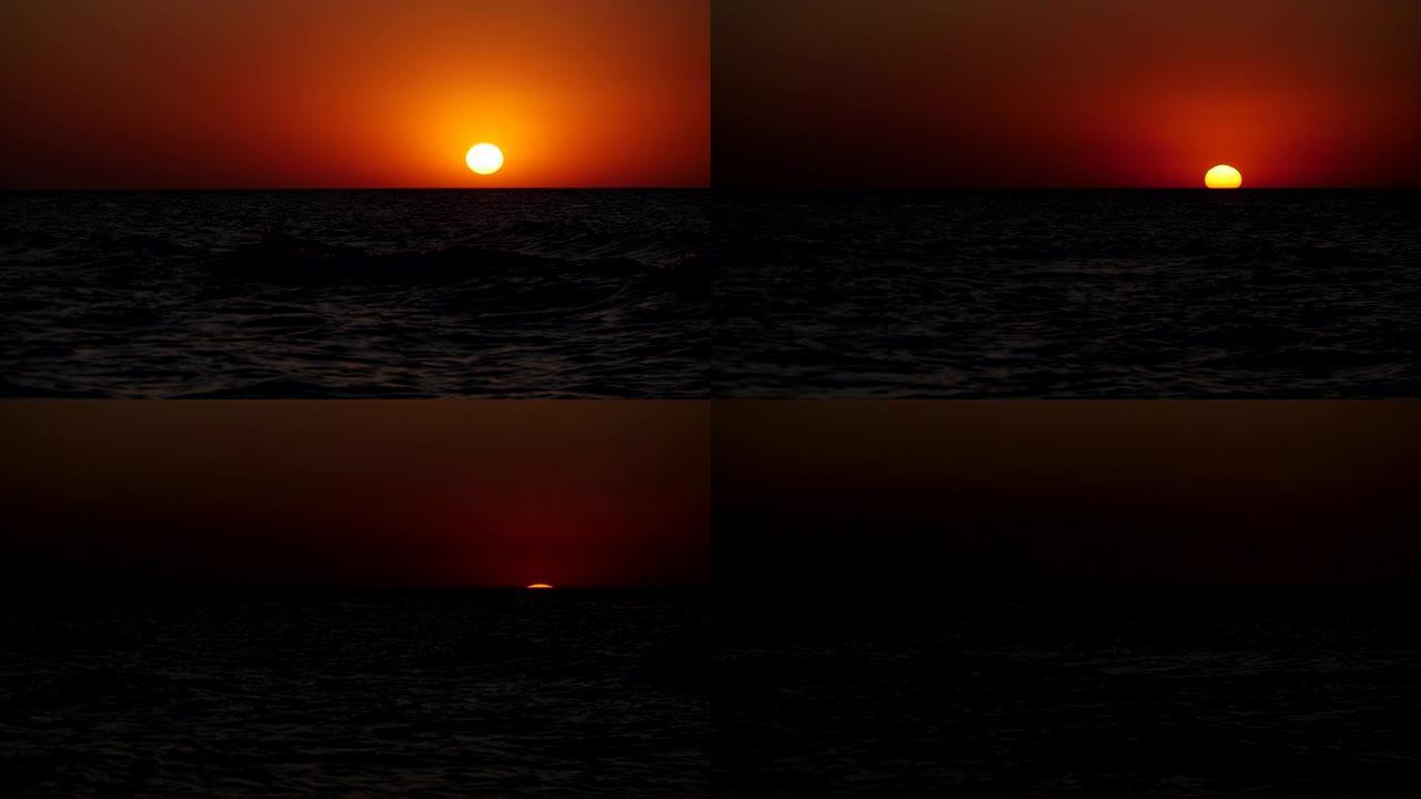 红色的太阳从地平线上落下，进入海洋。一个天体沉入海中。