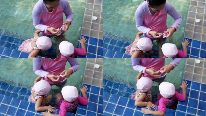 快乐的亚洲家庭在度假村的游泳池享受暑假。
