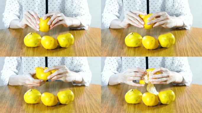 女人用手剥橘子。