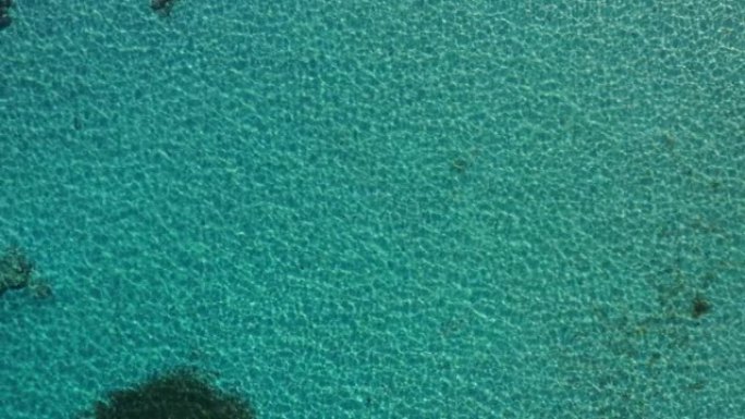 在希腊克里特岛，一个完美晶莹剔透的蓝色绿松石水的航拍画面。美丽的度假目的地场景，水晶般清澈的海水和珊