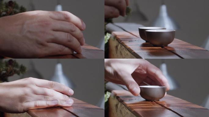 不露面的人在室内的木制桌子上拿茶杯的特写镜头