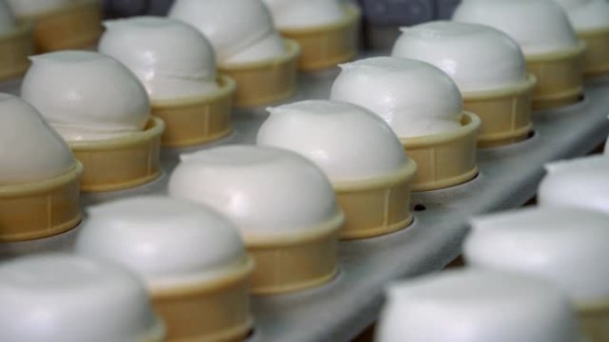 冰淇淋自动生产线。用冰淇淋填充威化饼杯。蛋筒冰淇淋。冰淇淋厂