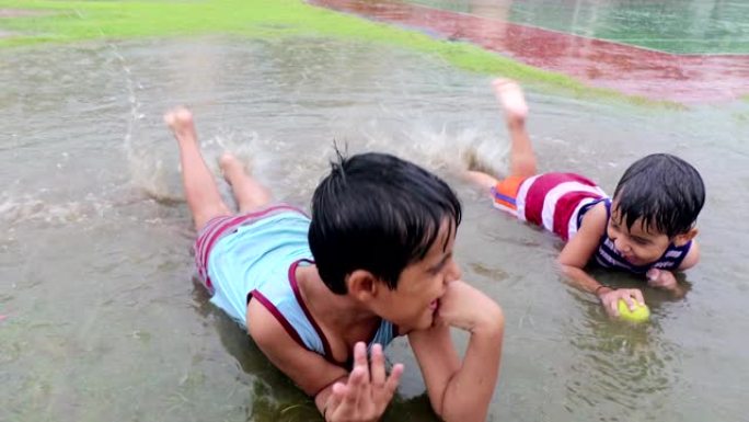 小学儿童在雨季在公园玩耍