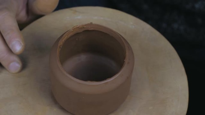 陶工将茶壶的边缘润滑脂，以将其固定在茶壶的另一部分上。茶道手工制作的粘土茶壶。棕色陶瓷茶壶。4k视频