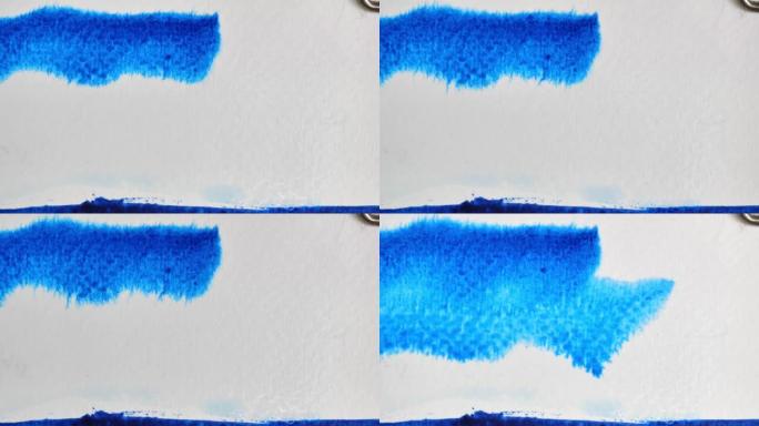 蓝色水彩在白色潮湿的表面上流动和扩散