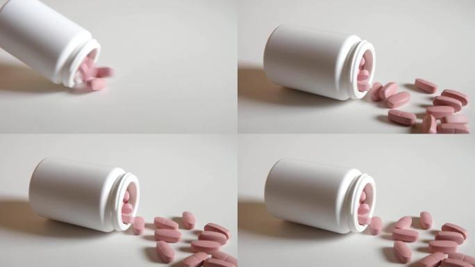 粉红色药丸以慢动作从桌子上的塑料管包装中滑出