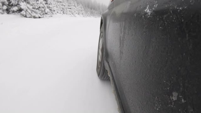 冬季下午，在山区国家公园的一条乡村道路上，低角度行驶在雪地里。