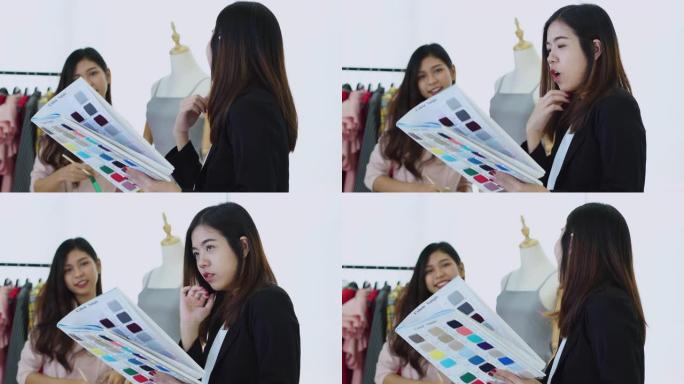 两名亚洲设计师选色裁缝服装以满足顾客需求