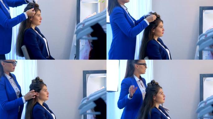 美发师在美容工作室为年轻女性模特做发型。