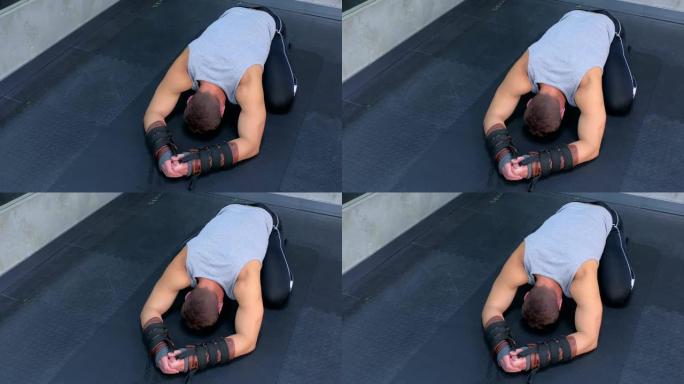 运动员在健身房使用教练进行肌筋膜伸展后，在垫子上休息。