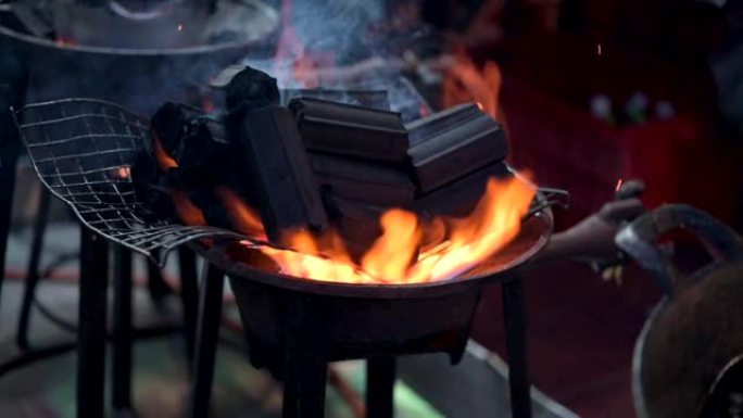 关闭泰国曼谷的慢动作街头美食厨师，通过在煤气炉上燃烧木炭作为烧烤菜单来准备食物。