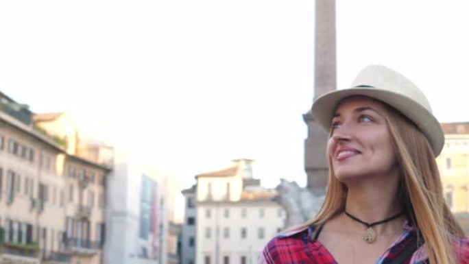 戴着帽子的快乐年轻女子，金发碧眼，走在纳沃纳广场。意大利罗马
