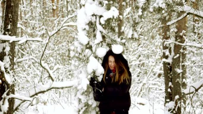 拉松雪树枝的女人。雪落在女孩的头上。慢动作。高清