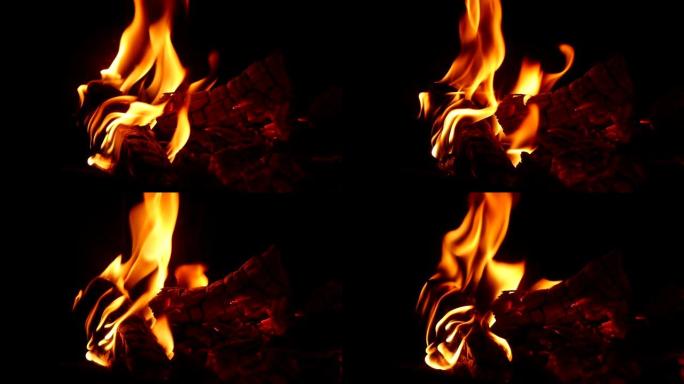 令人印象深刻的特写镜头，以神奇的方式在黑色壁炉中的charcoals和木制原木上燃烧着火焰。火看起来
