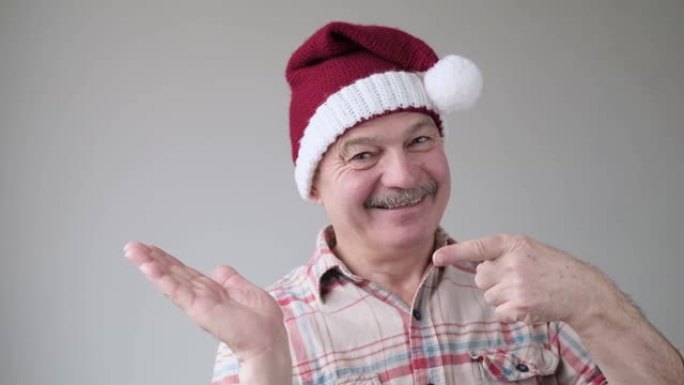 自信的内容高级西班牙裔男子戴着圣诞帽指着食指