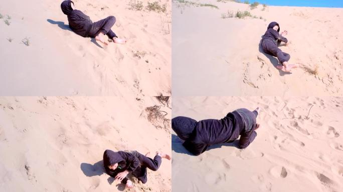 度假时，男孩正在海滩上的沙丘上玩耍。