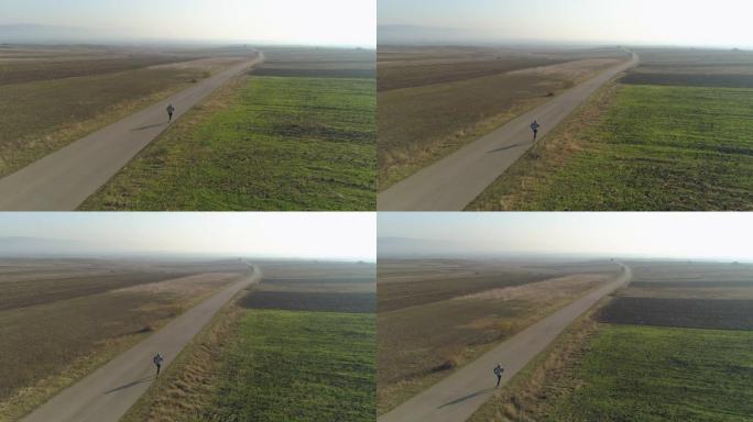 在乡村道路上慢跑的男子的无人机视图