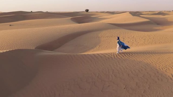 阿拉伯联合酋长国阿巴亚一名妇女旁边飞行的无人机的鸟瞰图