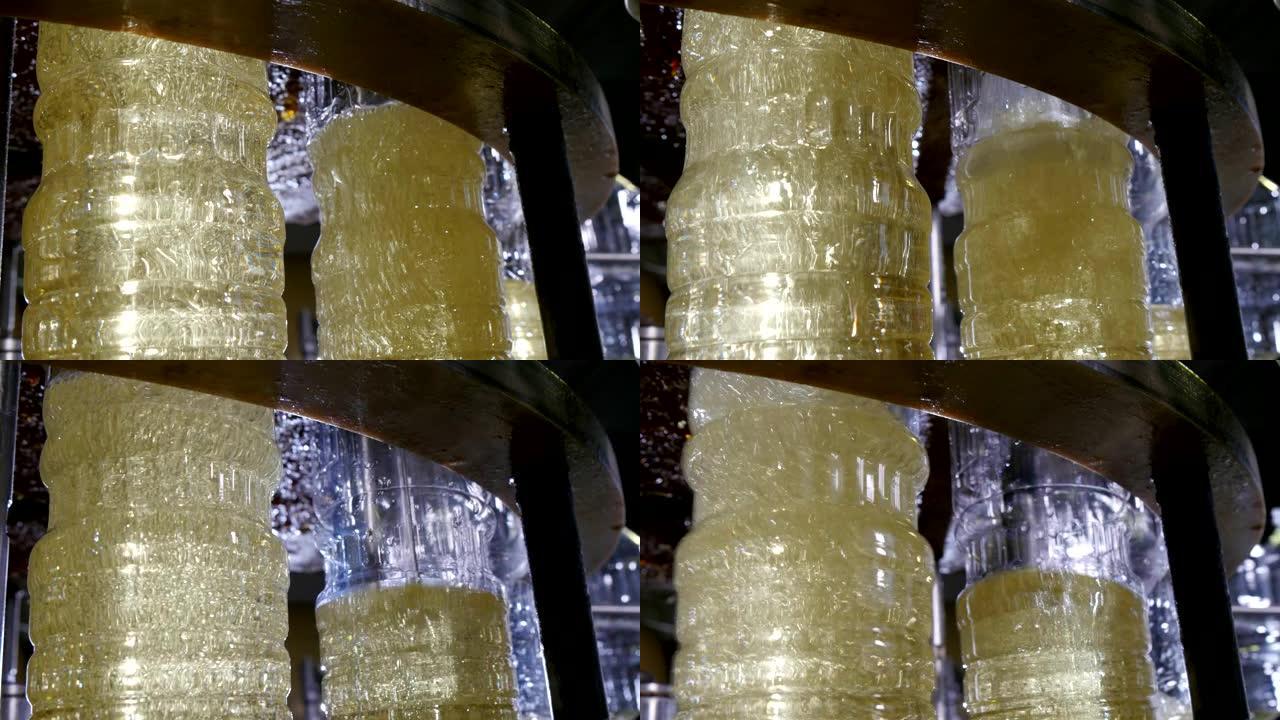 液体葵花籽油填充塑料瓶的精彩特写镜头在现代石油生产工厂的输送机上移动。