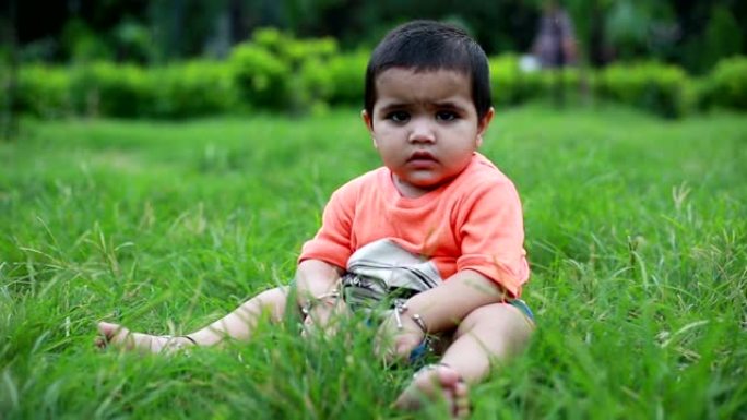 无辜的女婴在草地上玩耍