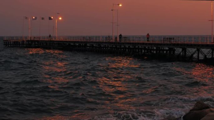 塞浦路斯利马索尔海岸码头，晚上有渔民和游客，地中海灯笼的光线反射得很漂亮
