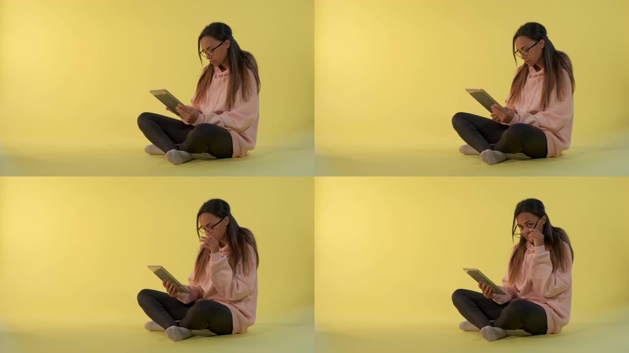 迷人的混血女孩在平板电脑上阅读一些东西，然后看着眼镜对着相机